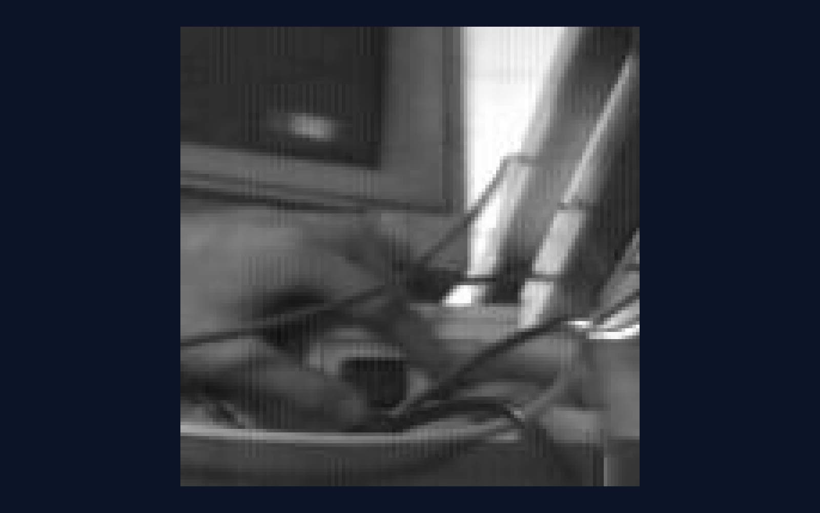 A tiny blurry black and white image showing fingers on a switch, enlarged so the pixels are visible