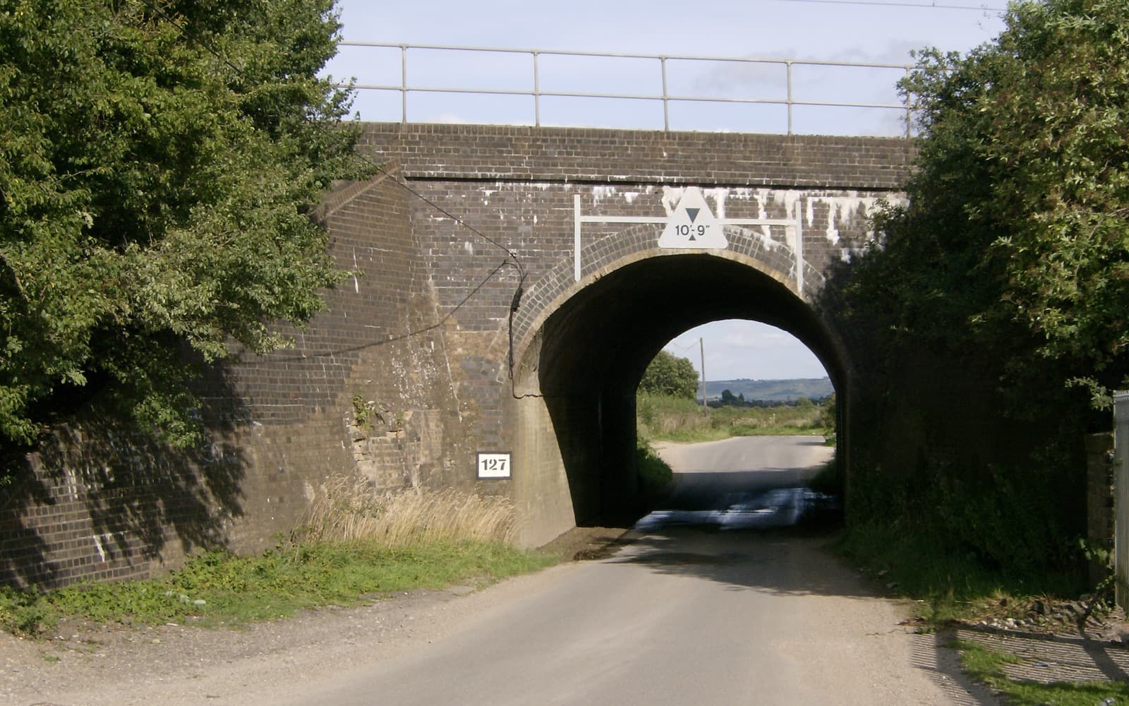 A small brick railway bridge over a quiet country lane in Buckinghamshire