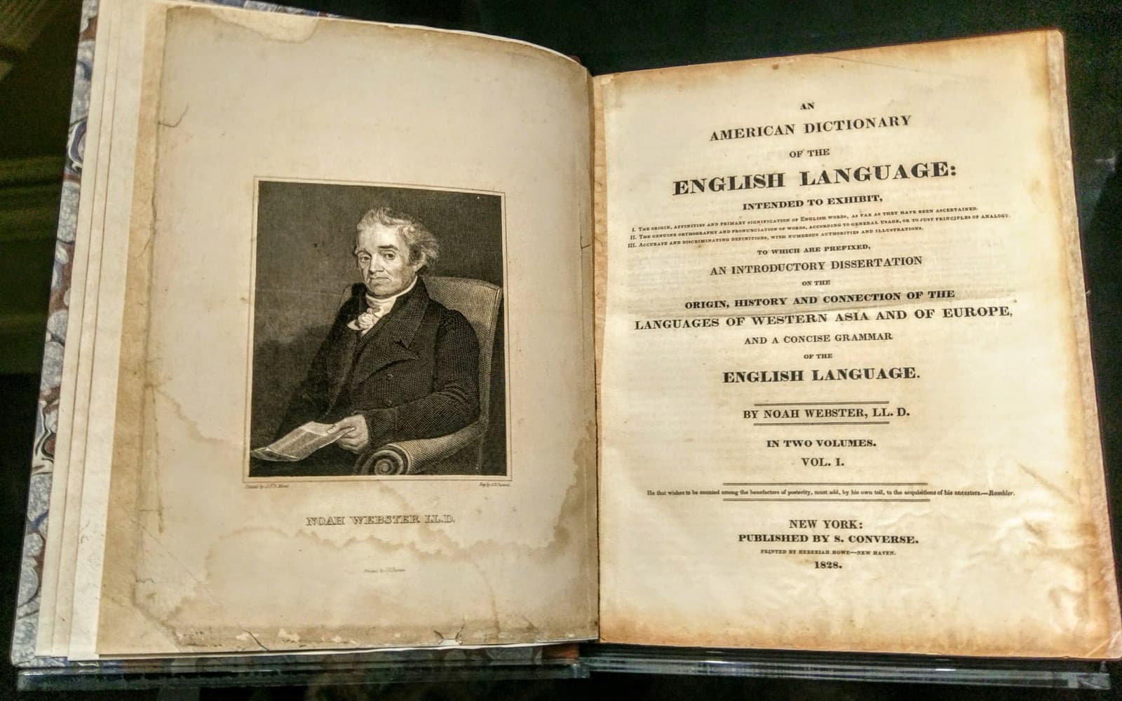 An open copy of Noah Webster's 1828 American Dictionary of the English Language, with his portrait facing the title page